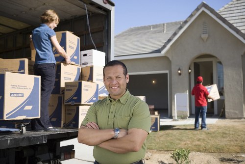 Professional movers carrying furniture through a Kennington property